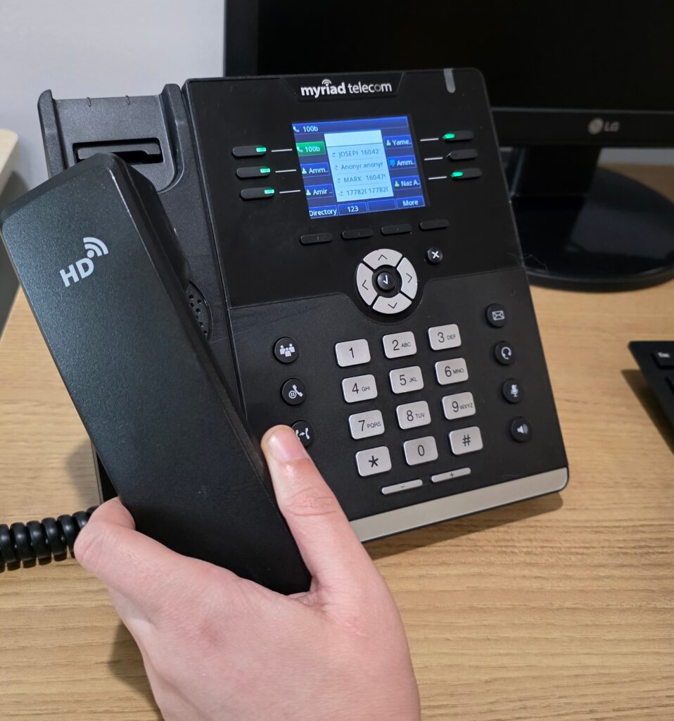 Business VoIP Systems That Keep Teams Connected | Myriad Technologies - Managed IT Support and Security Services in Chilliwack Office VoIP desk phone with digital display, keypad, and handset in use.